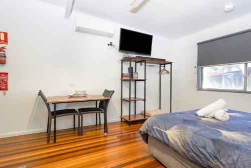 a bedroom with a desk and a bed and a table at Koala Lodge Studio 1 in Iluka