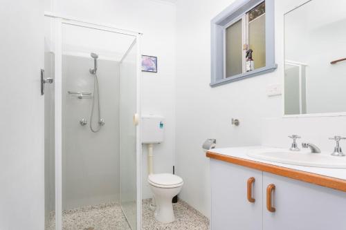 a bathroom with a shower and a toilet and a sink at Koala Lodge Studio 1 in Iluka