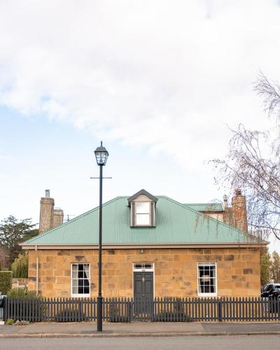 a brick building with a green roof and a street light at 101 Oatlands Tasmania in Oatlands