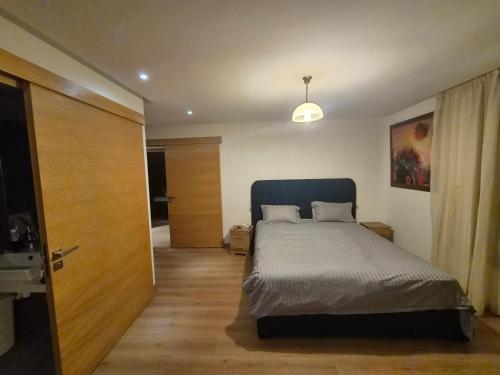 a bedroom with a bed and a wooden door at Best Sea View in Morocco in Sidi Bouqnadel