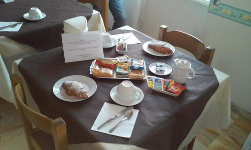 une table avec des assiettes de nourriture au-dessus dans l'établissement Pensione Aurora, à Imperia