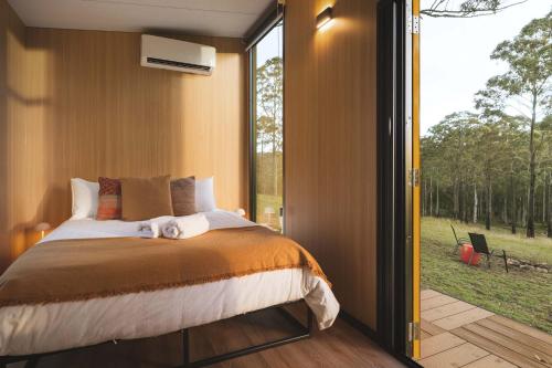 a bedroom with a bed and a large window at Three-Kalm & Four-Sol by Tiny Away in Rainbow Flat