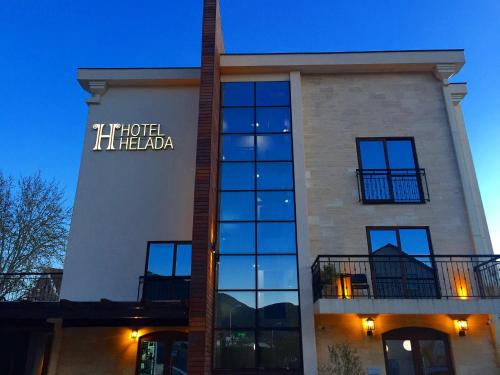 a building with a hotel hilton sign on it at Hotel Helada in Tivat