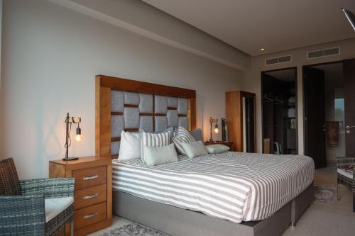 a bedroom with a large bed and a chair at Condo in Bucerías Beachfront Narval Norte in Bucerías