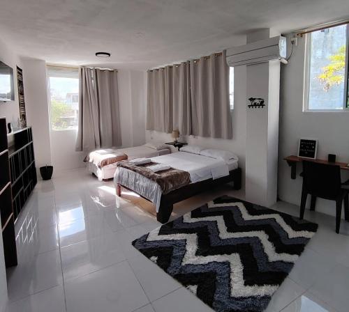 a bedroom with two beds and a rug at Galápagos Apartments in Puerto Ayora