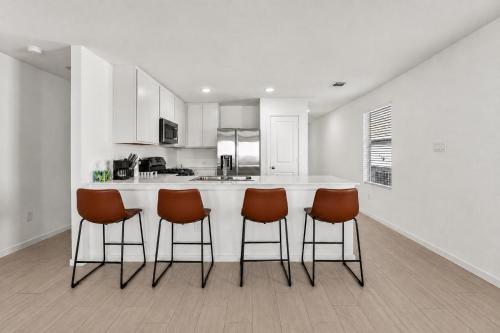a kitchen with a bar with four chairs around it at 3BR Near Gruene Historic District, Comal, and Guadalupe Rivers & Schlitterbahn in New Braunfels