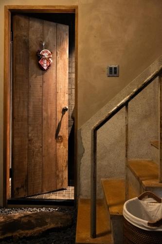 a wooden door with a wreath on it in a room at sishi hostel 巳時旅宿 in Tainan