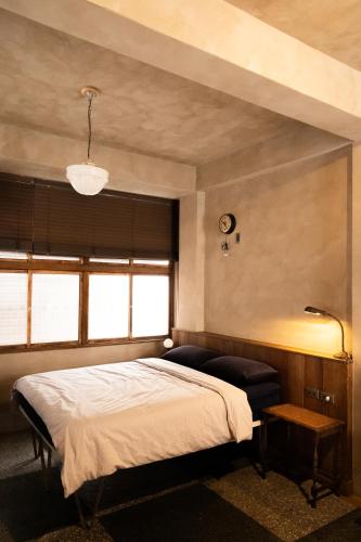 a bedroom with a large bed and a window at sishi hostel 巳時旅宿 in Tainan