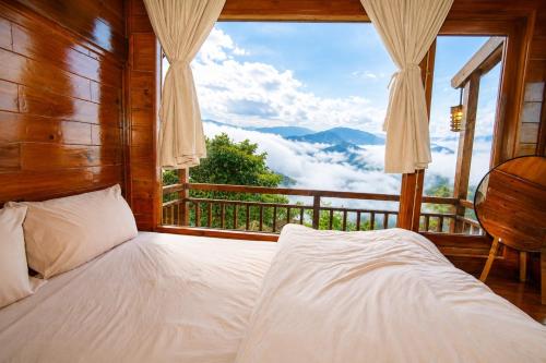 a bedroom with a bed with a view of the mountains at Mống Vàng Retreat Tà Xùa in Sơn La