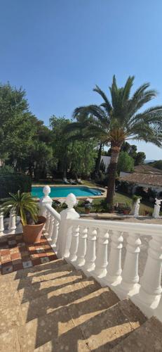 a white fence in front of a swimming pool at Mezquida del puerto in Jávea