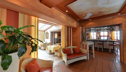 a restaurant with a table and chairs and a bar at Hotel Augsburger Hof in Augsburg