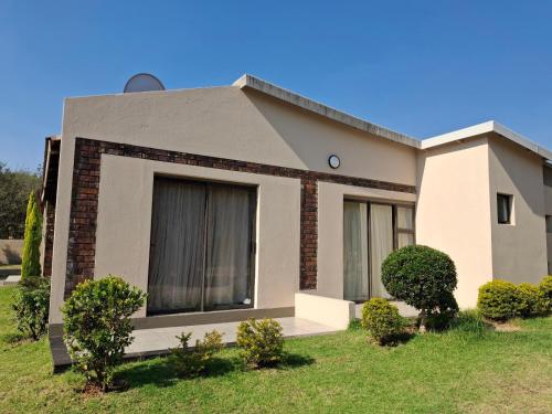 a house with bushes in front of it at Serene Pastures in Midrand
