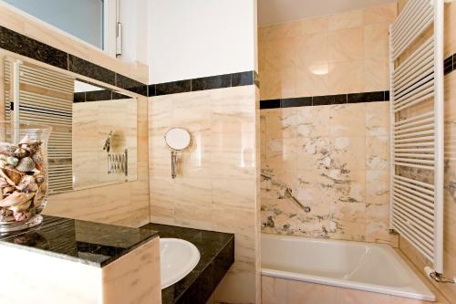 a bathroom with a tub and a sink at Sebnitzer Hof by STEIGER Hotels in Bad Schandau