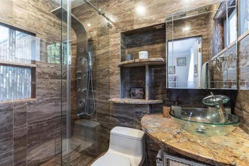 a bathroom with a sink and a glass shower at Luxury Waterfront Villa, With Private Hot Tub, Beachs, Aventura Mall Casinos, Restaruants in Hallandale Beach