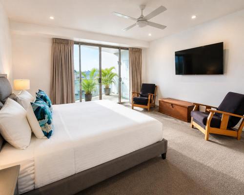 a bedroom with a large bed and a television at Space Holiday Apartments in Maroochydore