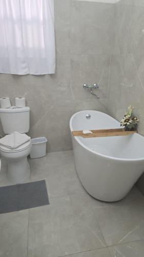 a bathroom with a white bath tub and a toilet at La Villas at Pos Chiquito Caribbean Paradise in Aruba in Savaneta