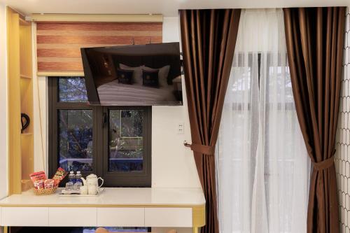 a room with a window with a tv on top at Sunrise Hotel Phước Kim in Bạc Liêu