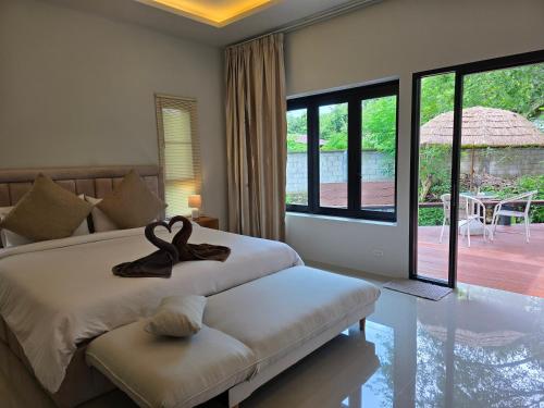 a bedroom with a bed and a large window at Mind's Homestay มายด์โฮมสเตย์ in Kampong Huaibū