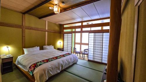 a bedroom with a bed in a room with a window at Komatsuya Seki Onsen in Myoko