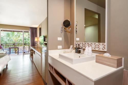 a bathroom with a sink and a mirror at SENTIDO Khao Lak in Khao Lak