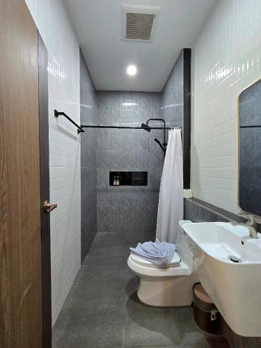 a bathroom with a toilet and a sink at Mind's Homestay มายด์โฮมสเตย์ in Kampong Huaibū