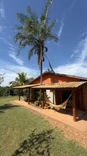 a building with a palm tree in front of it at Pousada & Chalés Quinta da Nascente - Serra da Canastra in Delfinópolis