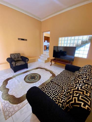 a living room with a couch and a flat screen tv at Vista Oceanica in Ocho Rios
