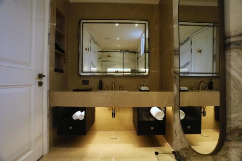 a bathroom with two sinks and a large mirror at Hotel Arif Castle, Nainital in Nainital