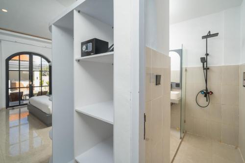 a room with white walls and a bathroom with a shower at Majestic Balangan in Uluwatu
