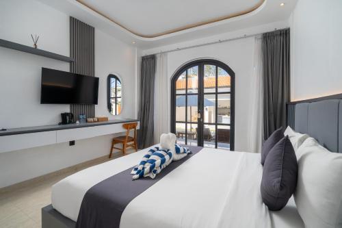 a bedroom with a large bed and a tv at Majestic Balangan in Uluwatu