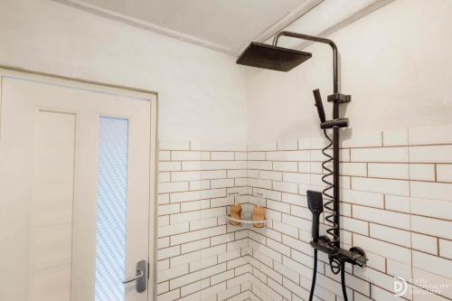 a shower in a bathroom with a white tiled wall at Suwehan Rey Cliff House in Nusa Penida