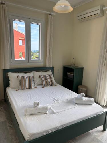 a bedroom with a large bed with two towels on it at Odysseia Apartments in Nikiana