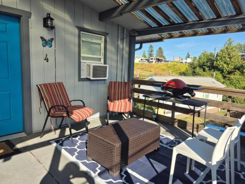 a porch with two chairs and a table and a grill at 2nd Floor Studio #4 with Ocean View and Covered Deck in Blaine