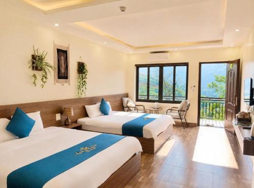 a hotel room with two beds and a balcony at Ánh Sao Sapa Hotel in Sapa