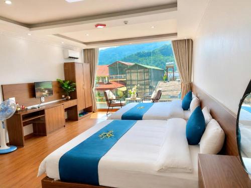 two beds in a room with a large window at Ánh Sao Sapa Hotel in Sapa