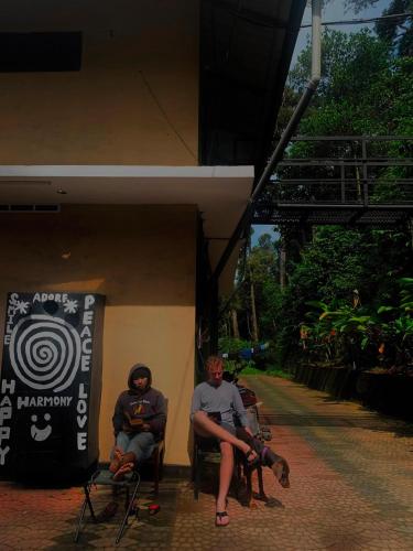 a group of people sitting in chairs next to a building at FREEDOM HOUSE, Munnar - A Backpackers Hostel in Munnar