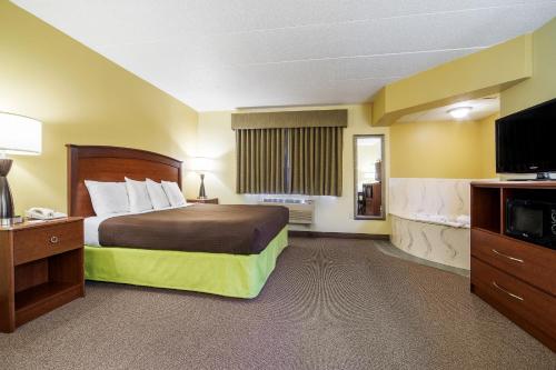 a hotel room with a bed and a flat screen tv at AmericInn by Wyndham Sioux Falls in Sioux Falls