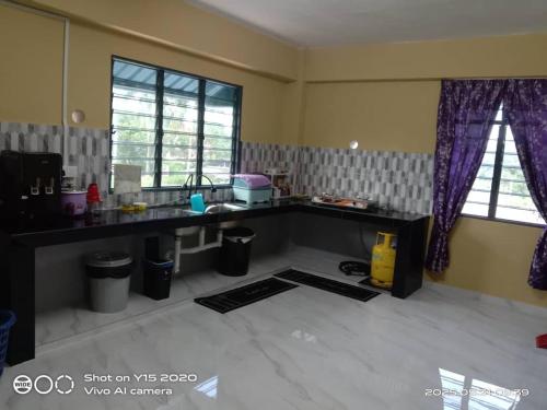 a kitchen with a counter and some windows at Qiffah Homestay in Kuala Terengganu