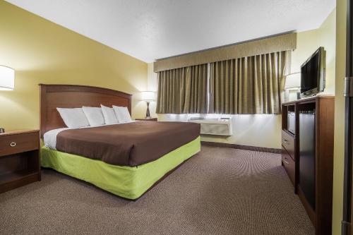 Habitación de hotel con cama y TV de pantalla plana. en AmericInn by Wyndham Sioux Falls, en Sioux Falls