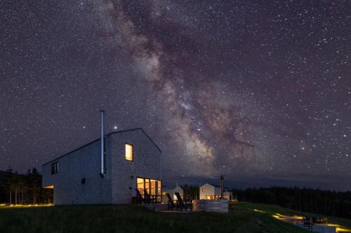 a barn at night with the milky way at Cedar - Luxury Oceanview Cottage with Hot Tub & Private Beach Access near Cabot Trail in Chimney Corner