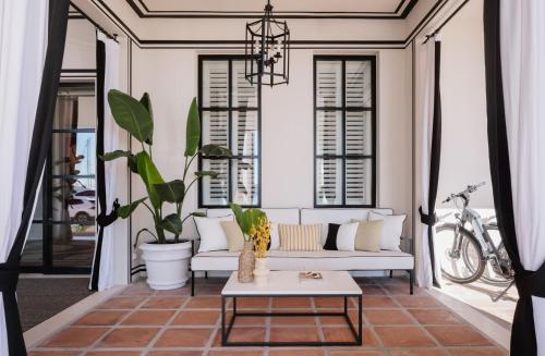 a living room with a white couch and a table at MiM Sotogrande member of Meliá Collection in Sotogrande