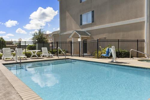 uma piscina com cadeiras e um parque infantil em Country Inn & Suites by Radisson, Saraland, AL em Saraland