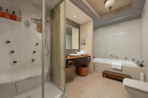 a bathroom with a shower and a sink and a tub at Greenland Mansion in Shanghai