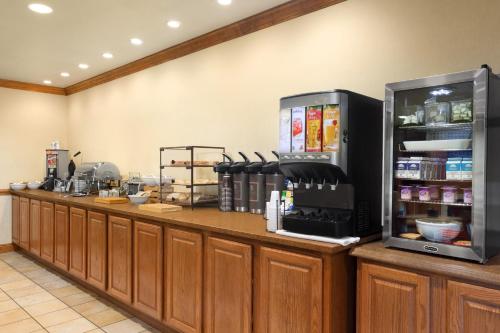 a kitchen with a counter with a refrigerator at Country Inn & Suites by Radisson, Saraland, AL in Saraland
