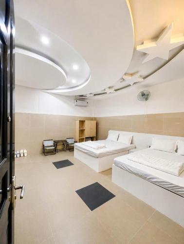 a large room with two beds and a large ceiling at Cảnh Việt Hotel in Tây Ninh