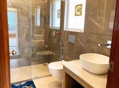 a bathroom with a shower and a toilet and a sink at The Boho Shantii Stays in Bhīm Tāl