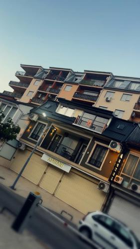 a tall building with many windows on a street at Gold City Hotel by Erebara in Debar