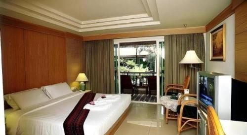 a hotel room with a bed and a television at Phi Phi Banyan Villa in Phi Phi Islands