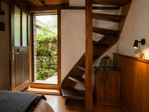 a bedroom with a wooden staircase leading to a window at B&B Osteria Morganti in Someo