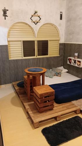 a bedroom with a bed and a table on a wooden platform at Fenergia Hospedagem Flexível in Pouso Alegre